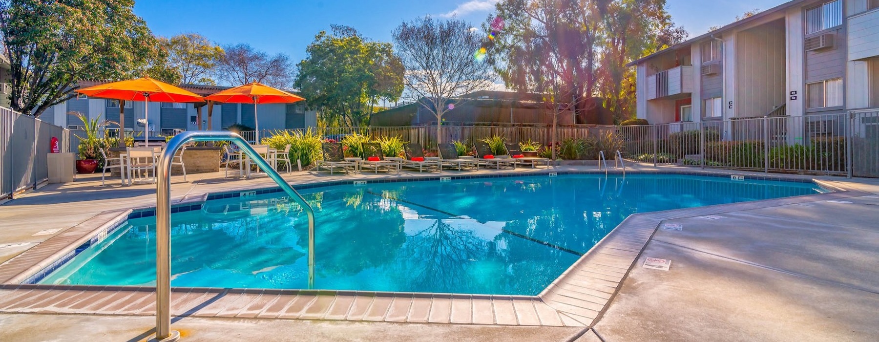 a swimming pool with chairs and umbrellas